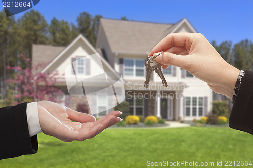 Image of Agent Handing Over the House Keys in Front of New Home