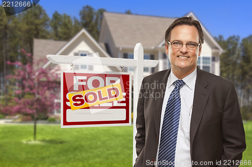 Image of Male Real Estate Agent in Front of Sold Sign and House