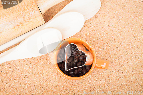 Image of Cup of coffee bean and cookies cutter in kitchen 