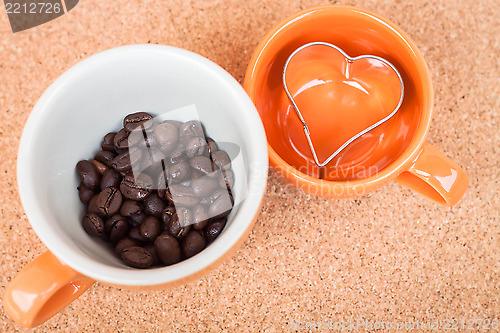 Image of Cup of coffee bean and cookies cutter on cork background