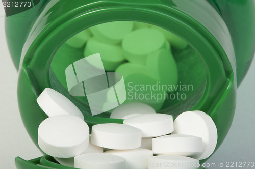 Image of White pills and a container