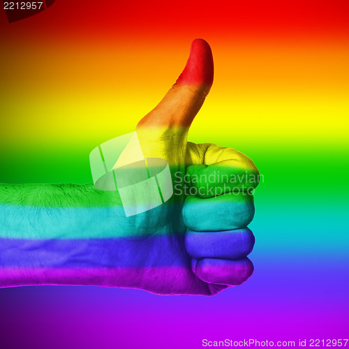 Image of Image of a mans hand showing thumb up, rainbow flag