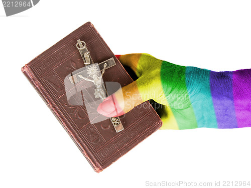 Image of Old hand (woman) holding a very old bible, rainbow flag