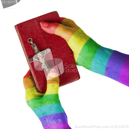 Image of Old hands holding a very old bible, rainbow flag pattern