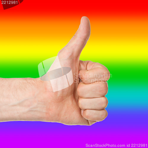 Image of Image of a mans hand showing thumb up, rainbow flag