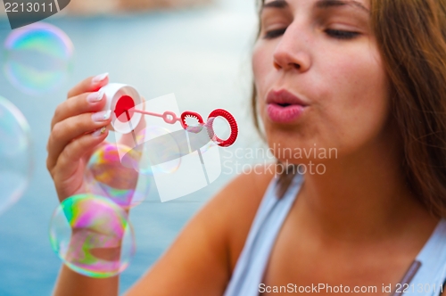 Image of Young woman blowing bubbles