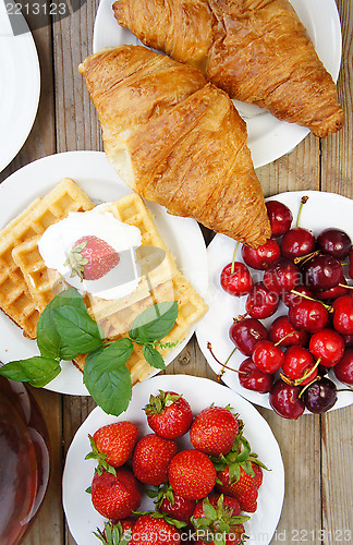Image of Tasty breakfast - tea, croissants, wafers and fruits