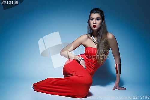 Image of Young glamour woman in red dress long hair