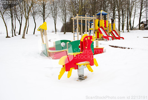 Image of empty colorful playground surrounded snow winter 