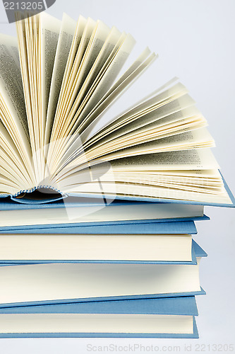 Image of A stack of blue books on light blue background