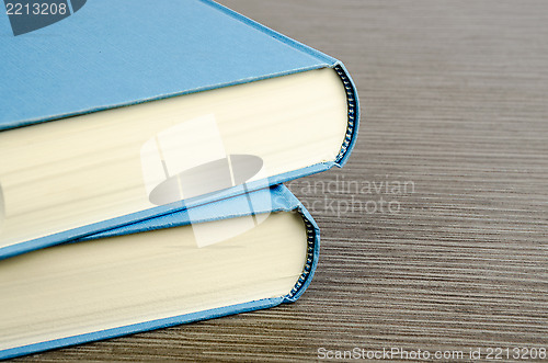 Image of Two blue books on a table with wooden texture