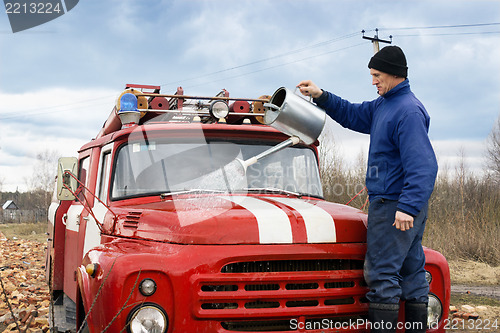 Image of A man washes the fire truck