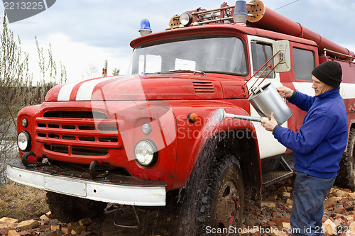 Image of The driver washes the old  fire truck