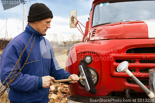 Image of A man washes the old fire truck