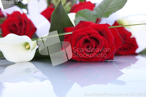 Image of Bouquet of fresh red roses and arum lilies