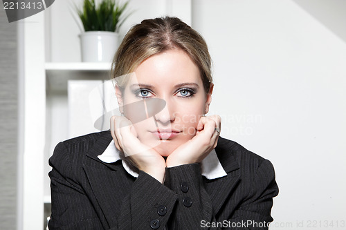 Image of Young businesswoman sitting thinking