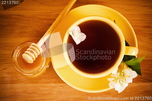 Image of The top view on a cup of tea with a flower of a jasmin and honey