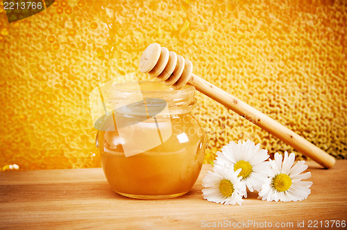 Image of jar of honey on the background of honeycombs 
