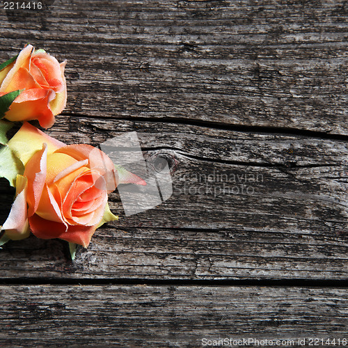 Image of Orange coloured roses on wooden planks