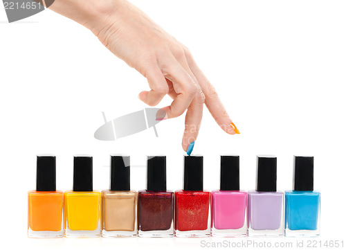 Image of Female hand fingers are the colored paints polish on a white bac