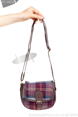 Image of fashionable plaid handbag in female hand.