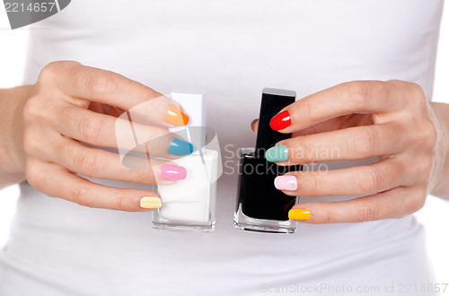 Image of Closeup of a hand holding bottles with two nail polish