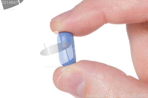 Image of Hand holding a blue pil