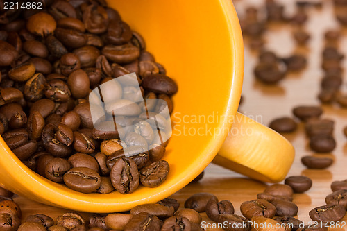 Image of Yellow cup with many coffee beans