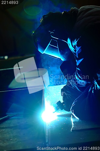 Image of welder with protective mask welding metal 