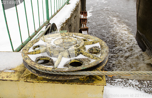 Image of dam mechanism steel cable snow river water winter 