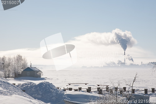 Image of small house and big factory