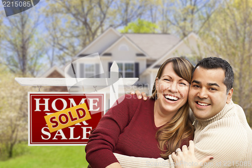 Image of Couple in Front of Sold Real Estate Sign and House