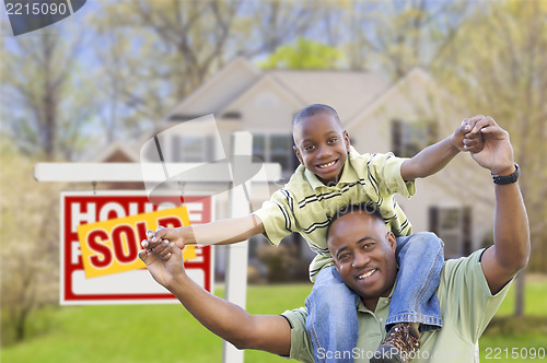 Image of Father and Son In Front of Real Estate Sign and Home