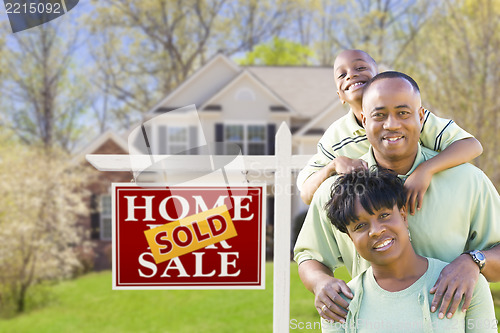 Image of African American Family In Front of Sold Sign and House