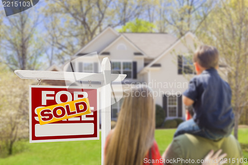 Image of Family Facing Sold For Sale Real Estate Sign and House