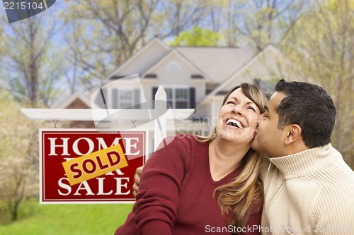 Image of Couple in Front of Sold Real Estate Sign and House