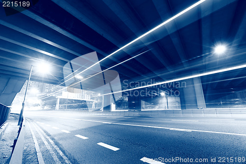 Image of traffic light through city at night in blue tone