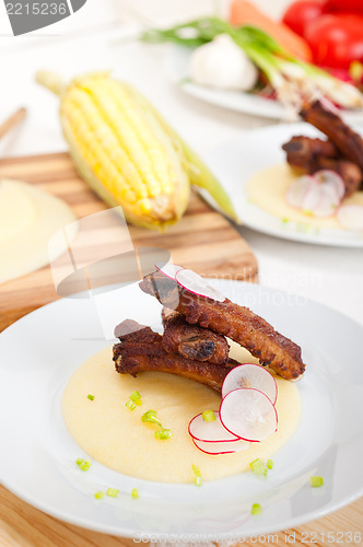 Image of pork ribs on polenta corn cream bed