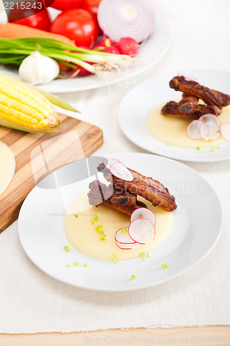 Image of pork ribs on polenta corn cream bed