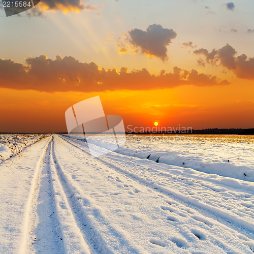 Image of red sunset over road with snow