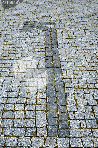 Image of cobbled road with arrow as background