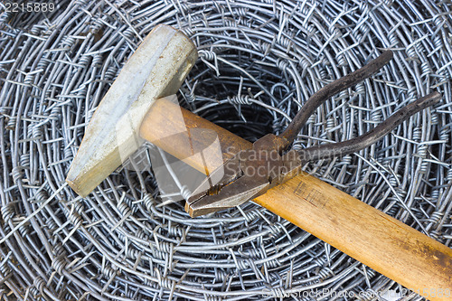 Image of Barbed wire, a hammer and pliers