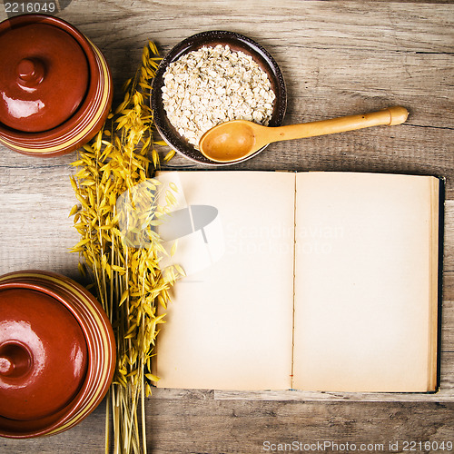 Image of The top view on the opened cookbook and kitchen utensils