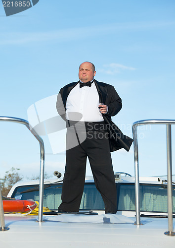 Image of Fat man in tuxedo with glass wine
