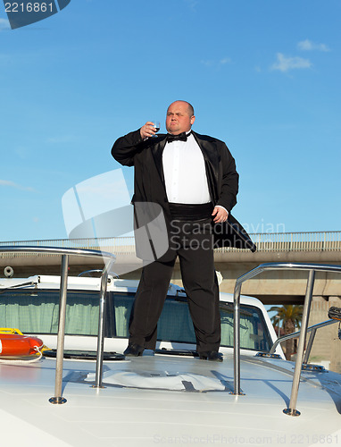 Image of Fat man in tuxedo with glass wine