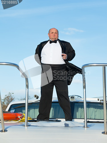 Image of Fat man in tuxedo with glass wine
