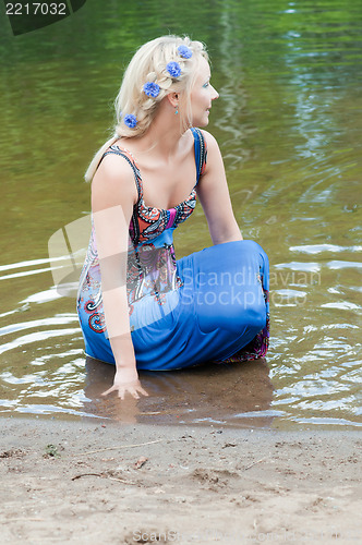 Image of Shot of beautiful woman sitting in the pond