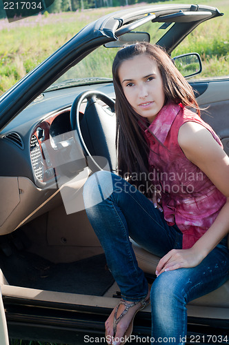 Image of Beautiful brunette woman sitting in the car