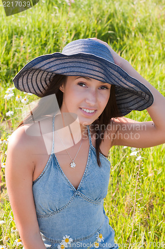 Image of Beautiful brunette woman in big denim hat