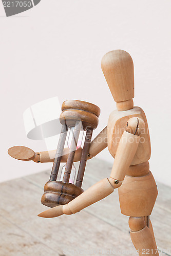 Image of Wood mannequin and hourglass display  time management